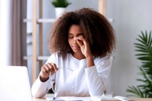 Woman rubbing her tired eyes from looking at computer screen.